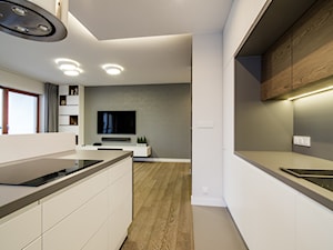 Kłobucka - Średnia otwarta biała szara z zabudowaną lodówką z podblatowym zlewozmywakiem kuchnia dwurzędowa z wyspą lub półwyspem z kompozytem na ścianie nad blatem kuchennym, styl nowoczesny - zdjęcie od Qbik Design