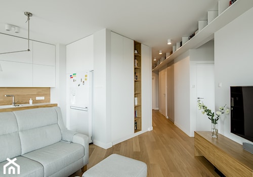 Osiedle Pod Zegarem - Średni biały salon z kuchnią z bibiloteczką, styl nowoczesny - zdjęcie od Qbik Design