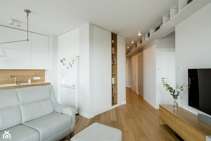 Osiedle Pod Zegarem - Średni biały salon z kuchnią z bibiloteczką, styl nowoczesny - zdjęcie od Qbik Design