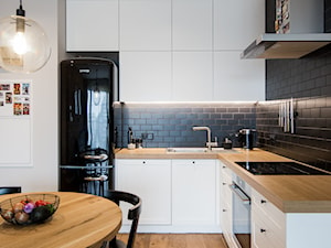 POMARAŃCZARNIA - Średnia otwarta z zabudowaną lodówką kuchnia w kształcie litery l - zdjęcie od Qbik Design