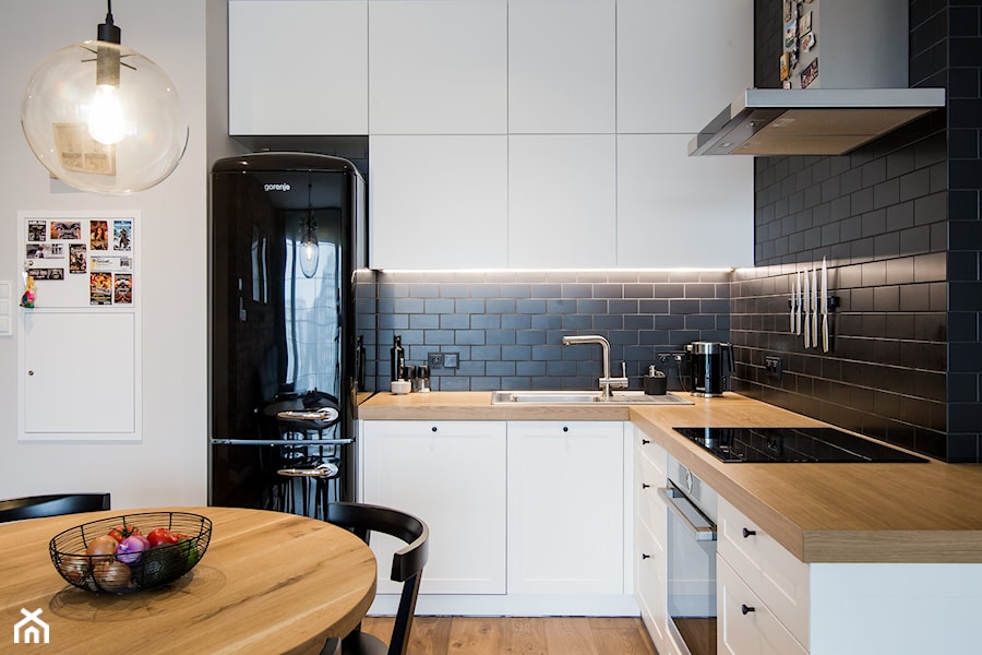 POMARAŃCZARNIA - Średnia otwarta z zabudowaną lodówką kuchnia w kształcie litery l - zdjęcie od Qbik Design