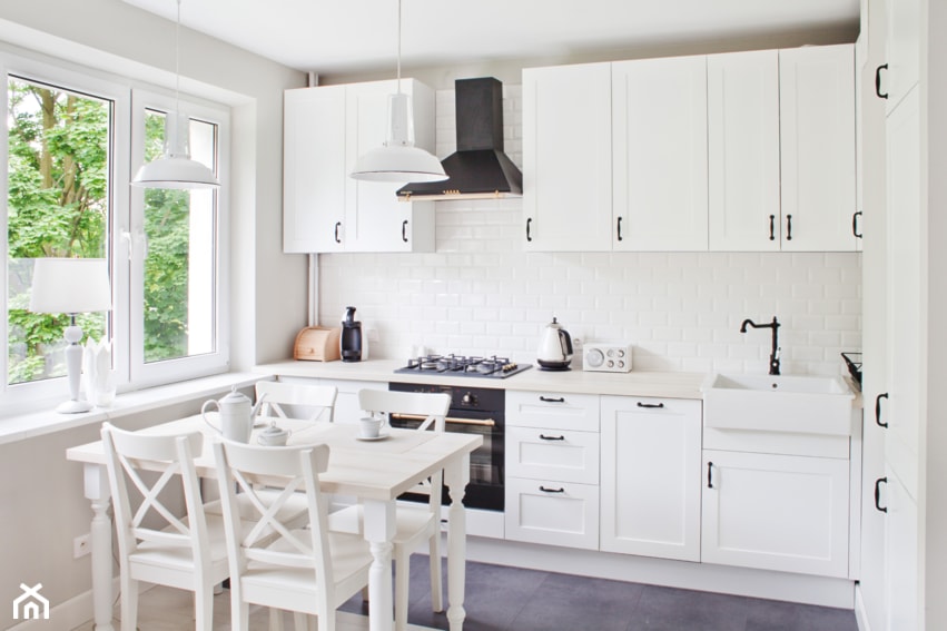 Sadyba - Średnia biała z zabudowaną lodówką z nablatowym zlewozmywakiem kuchnia w kształcie litery l, styl prowansalski - zdjęcie od Qbik Design