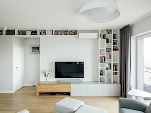 Osiedle Pod Zegarem - Średni biały salon z tarasem / balkonem z bibiloteczką, styl nowoczesny - zdjęcie od Qbik Design