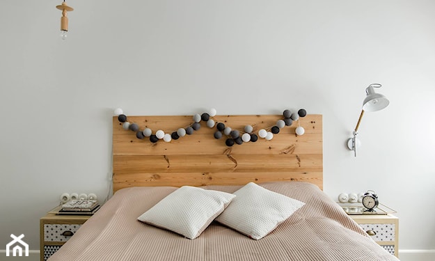 biała ściana, drewniany zagłówek, białe poduszki, beżowa narzuta na łóżko