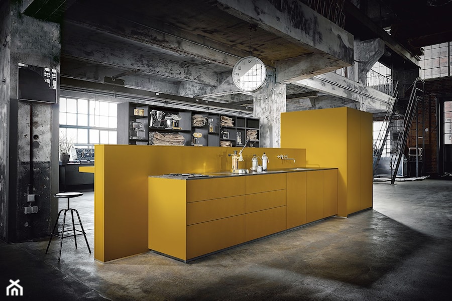 Kuchnie - Duża z żółtymi frontami otwarta żółta z zabudowaną lodówką z podblatowym zlewozmywakiem kuchnia dwurzędowa z oknem, styl industrialny - zdjęcie od Konzept - niemieckie kuchnie