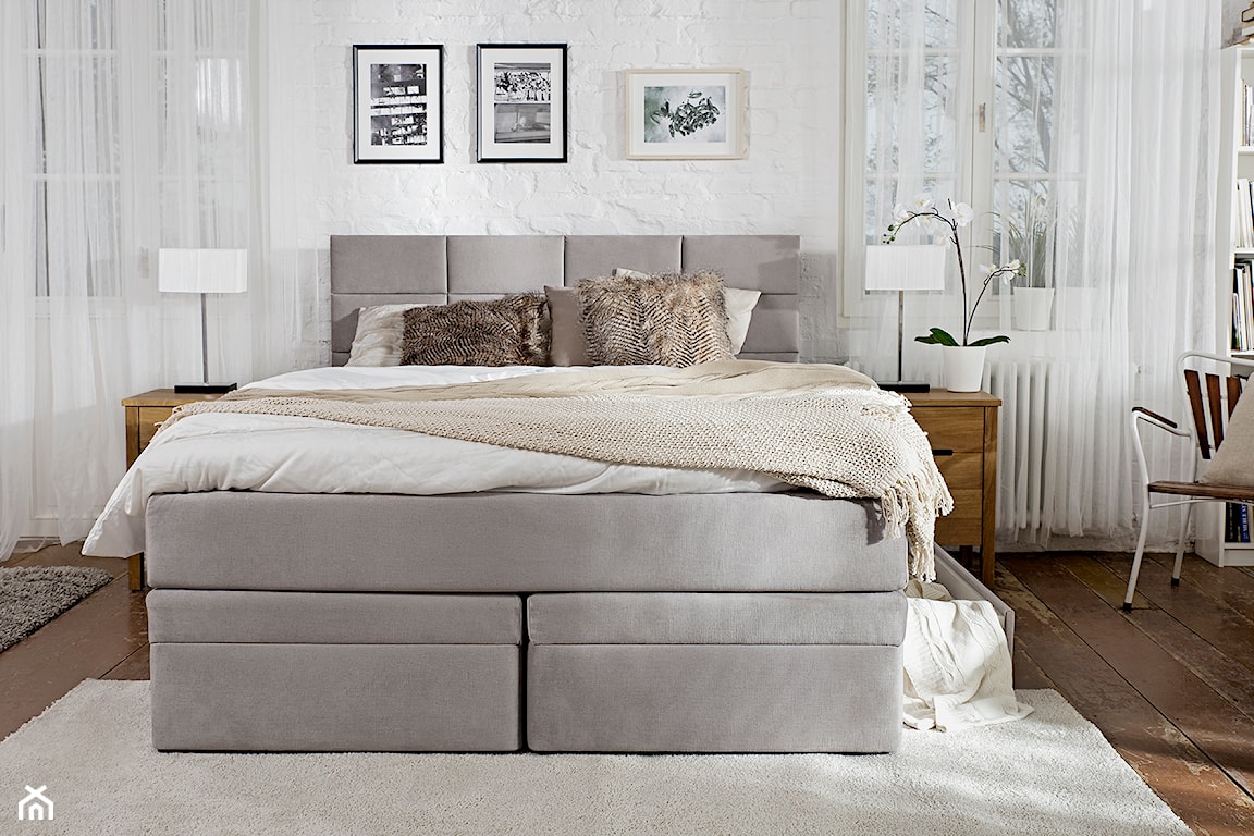 sypialnia w stylu eklektycznym z białą cegłą i drewnianą podłogą, szare łóżko tapicerowane  do sypialni