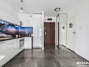 Apartament osiedle Bursztynowe Kołobrzeg - Duża zamknięta z kamiennym blatem biała z zabudowaną lodówką z nablatowym zlewozmywakiem kuchnia w kształcie litery l z oknem, styl nowoczesny - zdjęcie od PIOTR RUMIANOWSKI ARANŻACJE KUCHNI