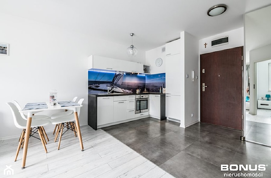 Apartament osiedle Bursztynowe Kołobrzeg - Otwarta z salonem z kamiennym blatem biała z zabudowaną lodówką z lodówką wolnostojącą z nablatowym zlewozmywakiem kuchnia w kształcie litery l z oknem, styl nowoczesny - zdjęcie od PIOTR RUMIANOWSKI ARANŻACJE KUCHNI