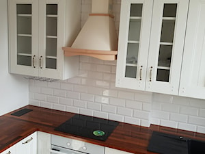 Kuchnia - Z salonem biała z zabudowaną lodówką z nablatowym zlewozmywakiem kuchnia w kształcie litery l, styl tradycyjny - zdjęcie od Kmeble