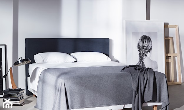 grafitowe łóżko na drewnianych nogach, sypialnia w stylu minimalistycznym, szara narzuta, biała pościel