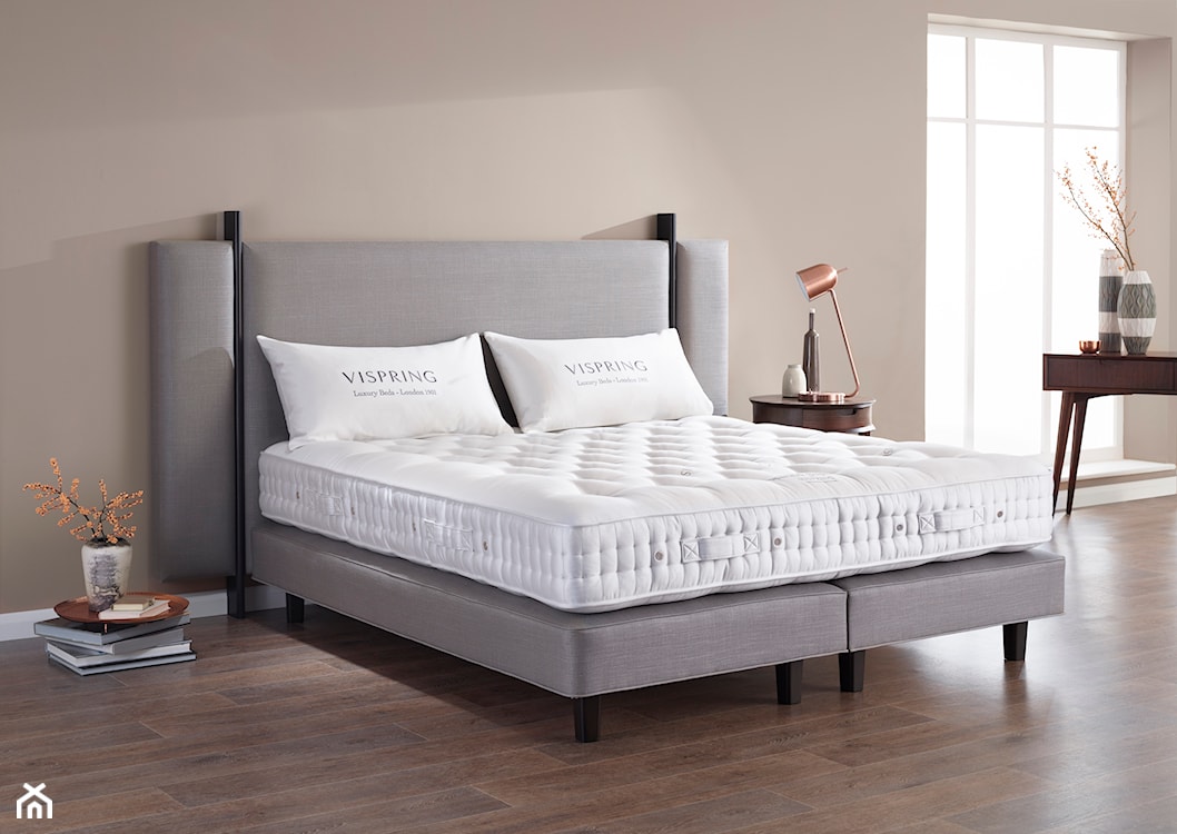 sypialnia w stylu minimalistycznym, szare łóżko na drewnianych nogach, drewniana podłoga, beżowe ściany