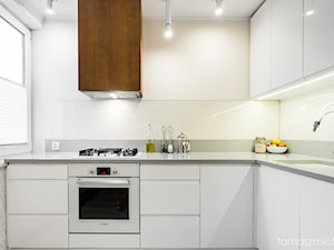 Fotografia wnętrz - Mała otwarta biała z zabudowaną lodówką z podblatowym zlewozmywakiem kuchnia w kształcie litery l z oknem, styl minimalistyczny - zdjęcie od Tomasz M