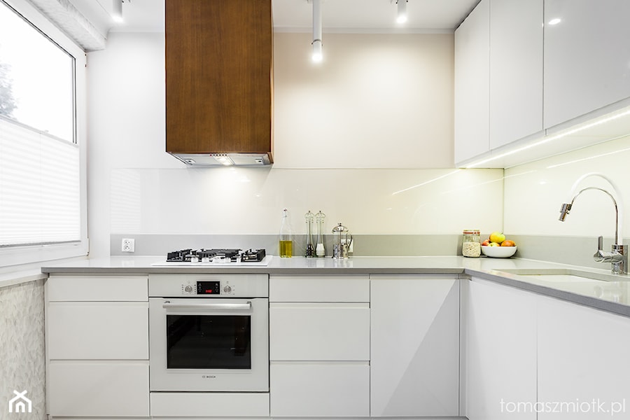 Fotografia wnętrz - Mała otwarta biała z zabudowaną lodówką z podblatowym zlewozmywakiem kuchnia w kształcie litery l z oknem, styl minimalistyczny - zdjęcie od Tomasz M