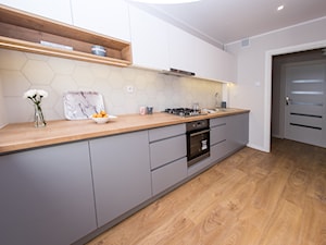 Mieszkanie na sprzedaż - Duża zamknięta szara z zabudowaną lodówką z nablatowym zlewozmywakiem kuchnia jednorzędowa, styl skandynawski - zdjęcie od Amicus Design