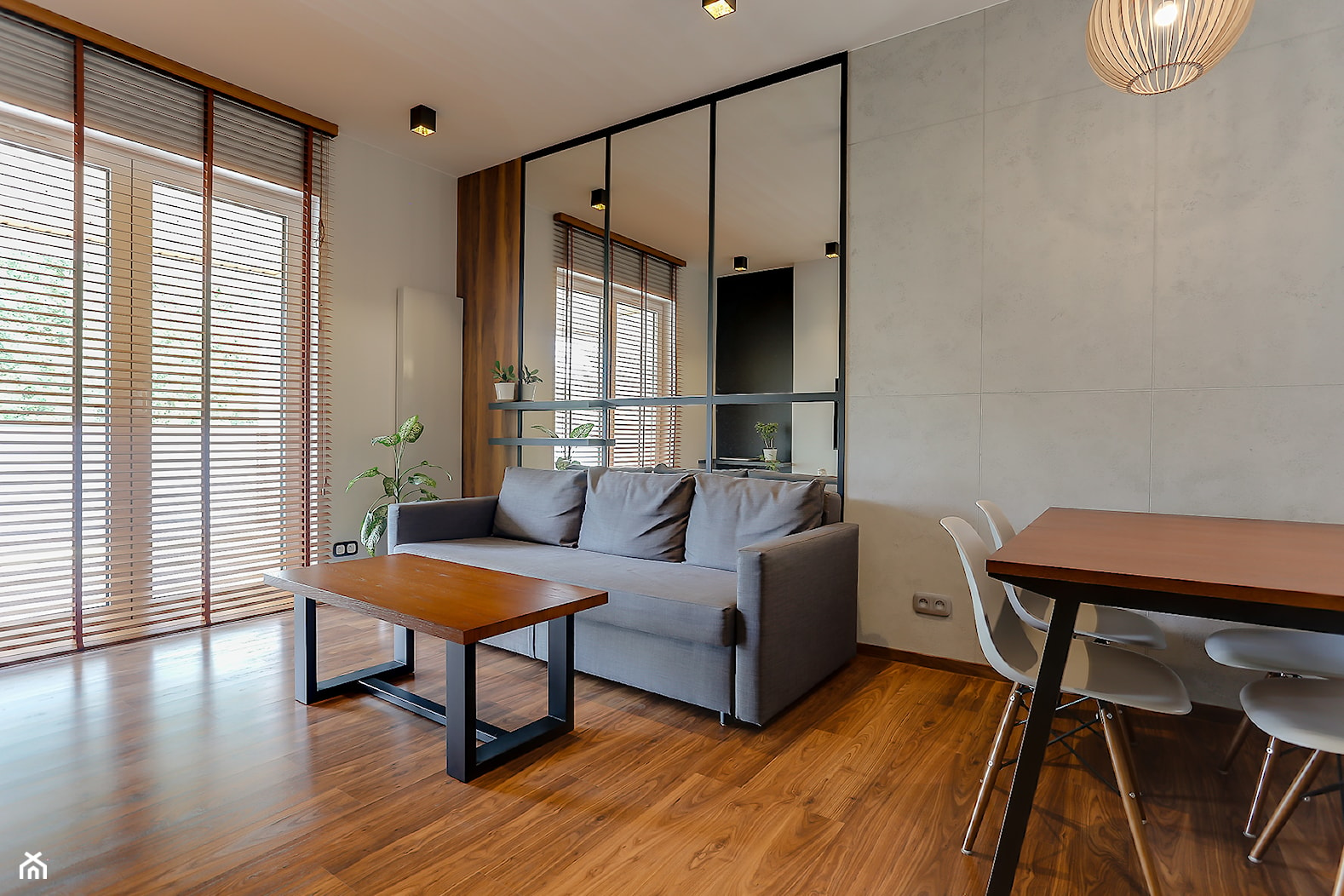 Mały salon z betonową ścianą oraz eleentami drewna i czerni. - zdjęcie od Atelier 37 | architektura & projektowanie wnętrz - Homebook