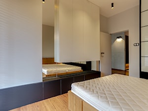 sypialnią z zabudowaną wiszącą szafką oraz lustrem - zdjęcie od Atelier 37 | architektura & projektowanie wnętrz