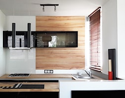 aneks kucenny z drewnianym blatem i ścianą dekoracyjną i czarnymi frontami - zdjęcie od Atelier 37 | architektura & projektowanie wnętrz - Homebook