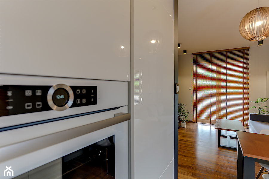 Biała kuchnia w ciepłym minimalistycznym salonie - zdjęcie od Atelier 37 | architektura & projektowanie wnętrz