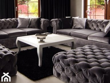 szara pikowana sofa, biały stolik, czarny dywanik, salon w stylu glamour