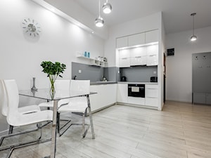 Apartamenty Platinum Szczecin - Mała z salonem biała szara z zabudowaną lodówką kuchnia w kształcie litery l - zdjęcie od Tomasz Wachowiec Fotografia