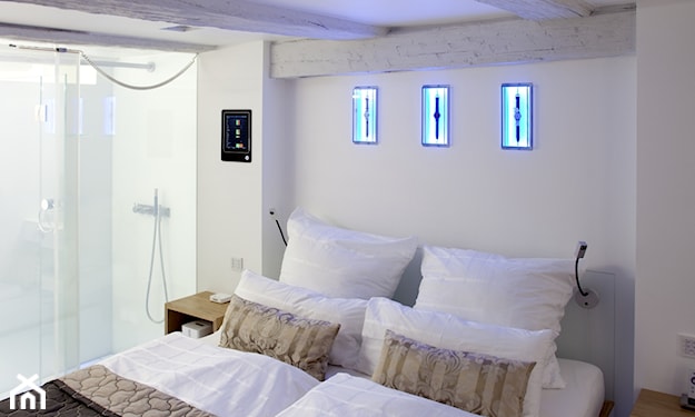 białe poduszki, beżowe poduszki, podświetlane dekoracje na ścianie