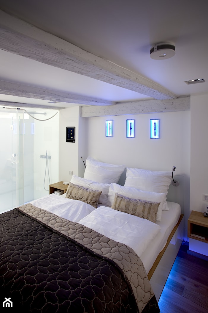 Gira Esprit – naturalne materiały, szkło, chrom, aluminium, stal, linoleum - Średnia biała sypialnia z łazienką, styl skandynawski - zdjęcie od GIRA - TEMA - Homebook