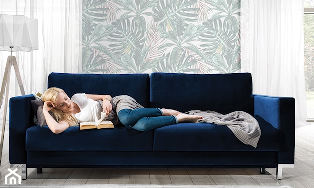 granatowa sofa, kobieta czytająca książkę na granatowej sofie