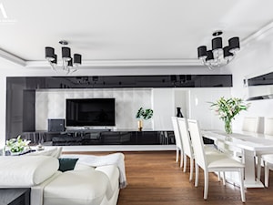 Projekt wnętrz apartamentu na Mokotowie. - Średni biały czarny salon z jadalnią, styl nowoczesny - zdjęcie od Aleksandra Wachowicz Architektura Wnętrz