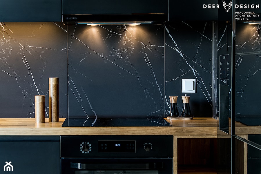 Postaw na czerń - Czarna z zabudowaną lodówką kuchnia w kształcie litery l z marmurem nad blatem kuchennym, styl minimalistyczny - zdjęcie od Deer Design