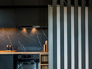 Postaw na czerń - Mała otwarta czarna z zabudowaną lodówką kuchnia jednorzędowa z marmurem nad blatem kuchennym, styl minimalistyczny - zdjęcie od Deer Design