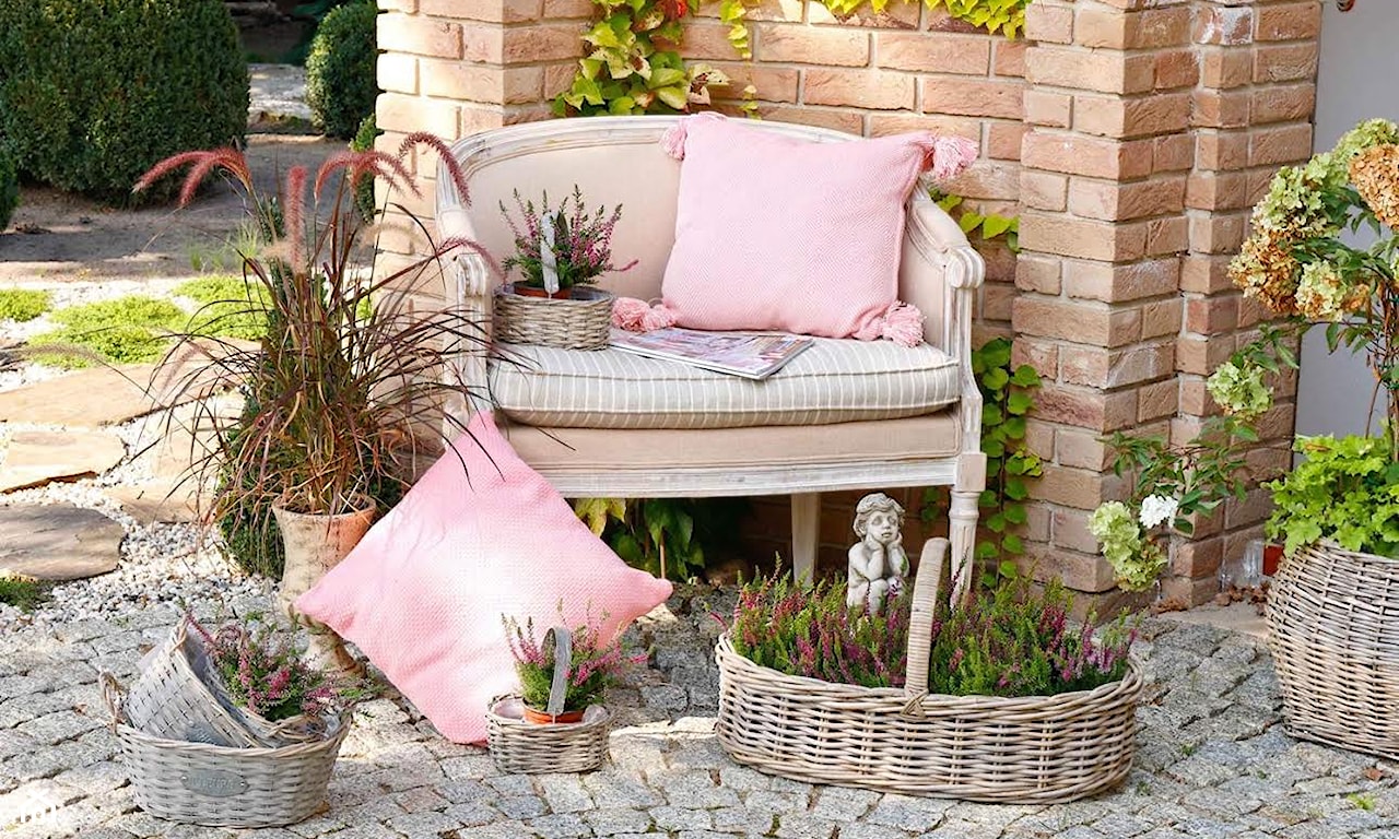 wiklinowe kosze, różowa poduszka, figurka anioła, jesienny ogród, wrzosy