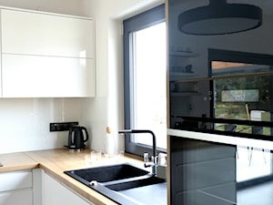 Realizacja AirPlane - Średnia otwarta z salonem biała z zabudowaną lodówką z nablatowym zlewozmywakiem kuchnia w kształcie litery l z oknem z kompozytem na ścianie nad blatem kuchennym, styl nowoczesny - zdjęcie od KODY Wnętrza | projektowanie wnętrz i doradztwo