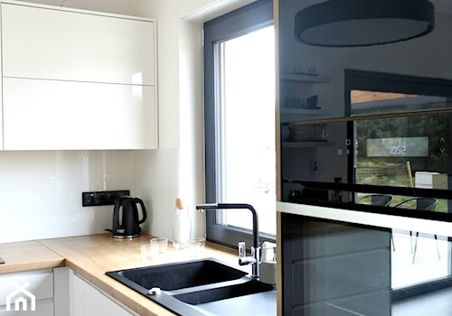 Realizacja AirPlane - Średnia otwarta z salonem biała z zabudowaną lodówką z nablatowym zlewozmywakiem kuchnia w kształcie litery l z oknem z kompozytem na ścianie nad blatem kuchennym, styl nowoczesny - zdjęcie od KODY Wnętrza | projektowanie wnętrz i doradztwo