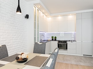 MIESZKANIE 72m2 - Mała otwarta z salonem biała z zabudowaną lodówką z podblatowym zlewozmywakiem kuchnia w kształcie litery l z kompozytem na ścianie nad blatem kuchennym, styl minimalistyczny - zdjęcie od KRAMKOWSKA | PRACOWNIA WNĘTRZ