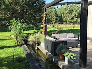 Dom "stodoła" na skraju lasu - Duży z meblami ogrodowymi z donicami na kwiaty taras z tyłu domu, styl nowoczesny - zdjęcie od Helena Michel Design