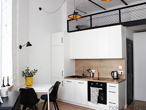 Małe mieszkanie z antresolą, 20m2. - Mała otwarta biała z zabudowaną lodówką z lodówką wolnostojącą z nablatowym zlewozmywakiem kuchnia jednorzędowa z oknem, styl industrialny - zdjęcie od Hokum Architekci