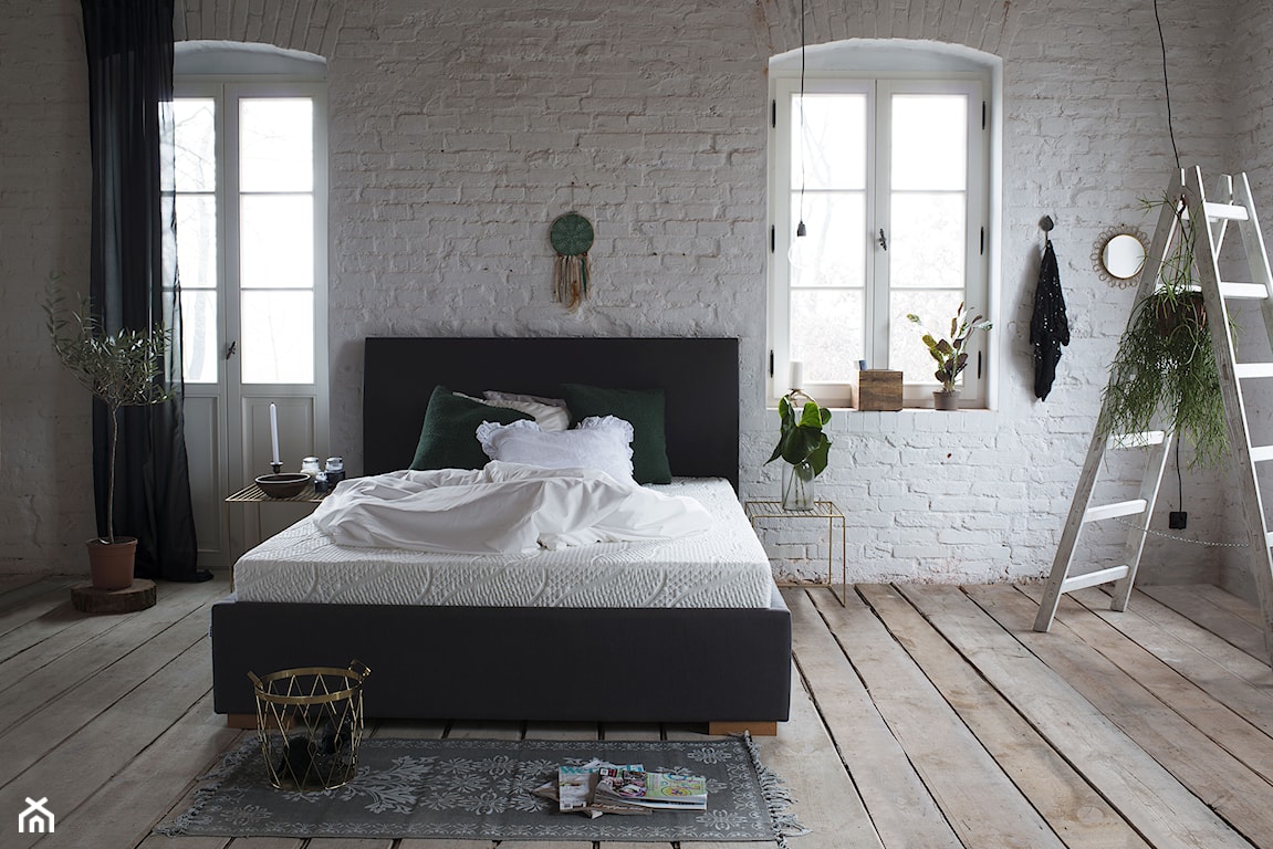 Sypialnia z łóżkiem dwuosobowym z materacem, biała cegła na ścianie w sypialni