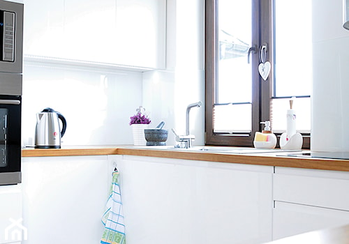 Biała kuchnia z drewnem. - Mała otwarta zamknięta biała z zabudowaną lodówką kuchnia w kształcie litery l, styl nowoczesny - zdjęcie od Joanna Stelmaszczuk Projektowanie Wnętrz