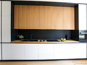 Kuchnia czarno-biała z ocieplającym, naturalnym drewnem - zdjęcie od sandroom