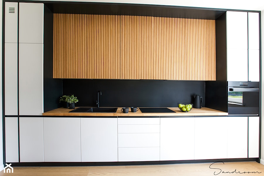 Kuchnia czarno-biała z ocieplającym, naturalnym drewnem - zdjęcie od sandroom