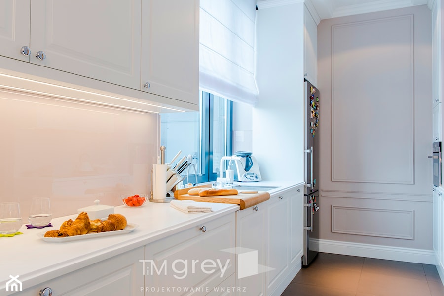Nowojorski Apartament - Średnia z salonem biała z zabudowaną lodówką z podblatowym zlewozmywakiem kuchnia w kształcie litery u z kompozytem na ścianie nad blatem kuchennym, styl glamour - zdjęcie od TiM Grey Projektowanie Wnętrz