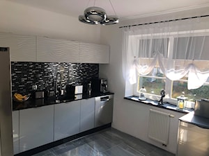 Meble kuchenne marki Stolzen - Średnia otwarta biała czarna z zabudowaną lodówką z lodówką wolnostojącą z podblatowym zlewozmywakiem kuchnia w kształcie litery l z oknem - zdjęcie od STOLZEN Meble Kuchenne