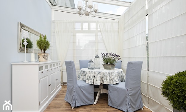 przeszklony ogród zimowy w stylu glamour, krzesła z niebieskim obiciem, biały okrągły stolik