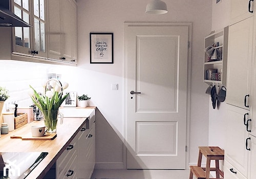 Mieszkanie w stylu skandynawskim - Mała otwarta biała z zabudowaną lodówką z nablatowym zlewozmywakiem kuchnia dwurzędowa z oknem, styl skandynawski - zdjęcie od ania.home