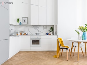 Minimalistyczne wnętrze na Powiślu - Średnia z salonem biała z zabudowaną lodówką z podblatowym zlewozmywakiem kuchnia w kształcie litery l - zdjęcie od One Design