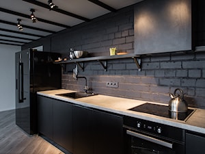 Minimalistyczny loft na Litwie - Średnia z salonem z kamiennym blatem czarna z zabudowaną lodówką z lodówką wolnostojącą z podblatowym zlewozmywakiem kuchnia jednorzędowa, styl industrialny - zdjęcie od Homebook Design