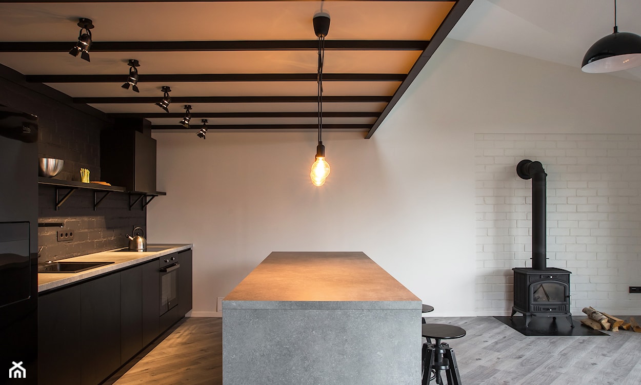 kuchnia w stylu industrialnym, czarne szafki, betonowe blaty, drewniana podłoga