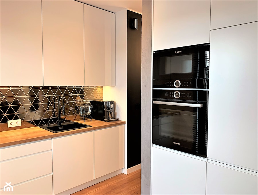 Niewielki dom na Maślicach - realizacja projektu - Średnia zamknięta biała czarna z zabudowaną lodówką z nablatowym zlewozmywakiem kuchnia w kształcie litery g z oknem, styl nowoczesny - zdjęcie od DekoDeko