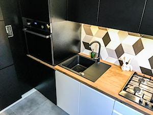 Realizacja kuchni w bloku z lat 80-tych - Mała zamknięta czarna z zabudowaną lodówką z nablatowym zlewozmywakiem kuchnia w kształcie litery l, styl nowoczesny - zdjęcie od DekoDeko