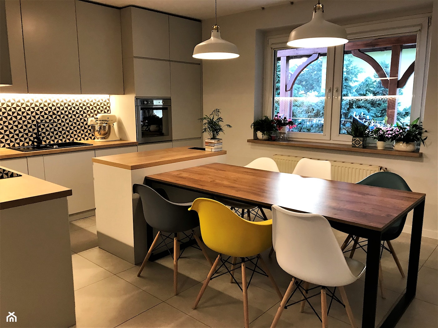Kuchnia z roślinną tapetą i wielkim stołem - realizacja projektu - Średnia szara jadalnia w kuchni, styl nowoczesny - zdjęcie od DekoDeko - Homebook